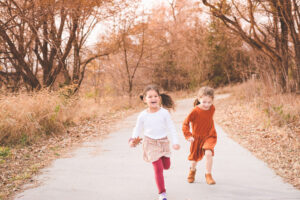 bff photoshoot by jess lightner photography at Standing Bear Lake. Two girls running and playing.